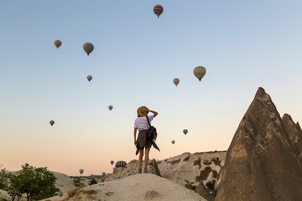 Young woman and hot air ballons, Goreme, Cappadocia, Turkey